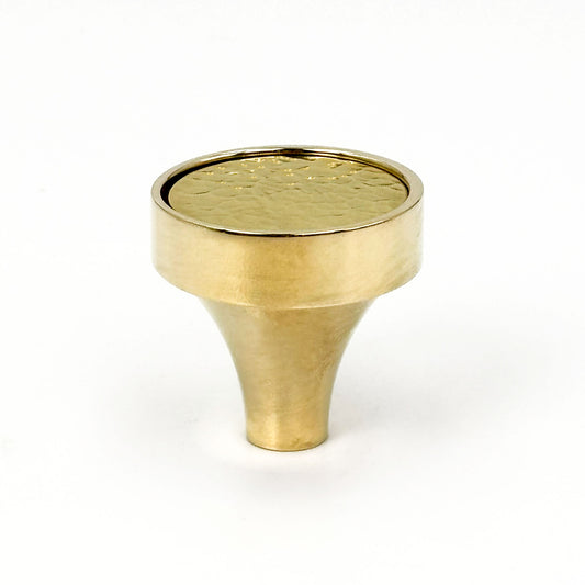 Brass cabinet knob with a textured surface on a white background