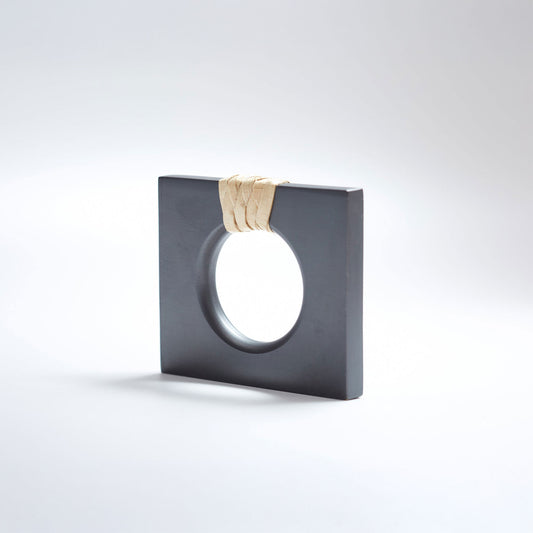 A petite square dark gray ring-shaped cabinet knob with a circular cutout, featuring a light natural beige woven cord wrapped around the top edge, set against a white background.