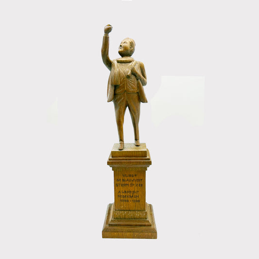 Wooden Statue of a Man with an inscription on the base, his hand is raised up over his head