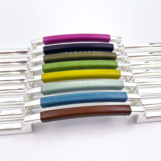 metal cabinet pulls with colorful leather handles on a white background