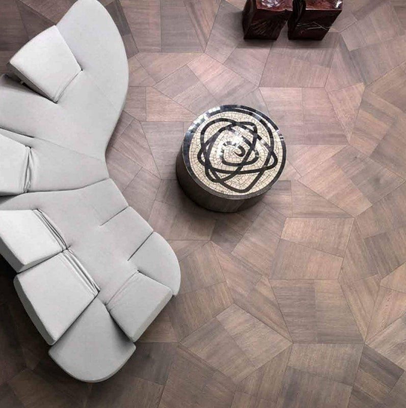 A birds eye view of a modern living room and curved sofa atop Natural Genius Slide wood flooring.