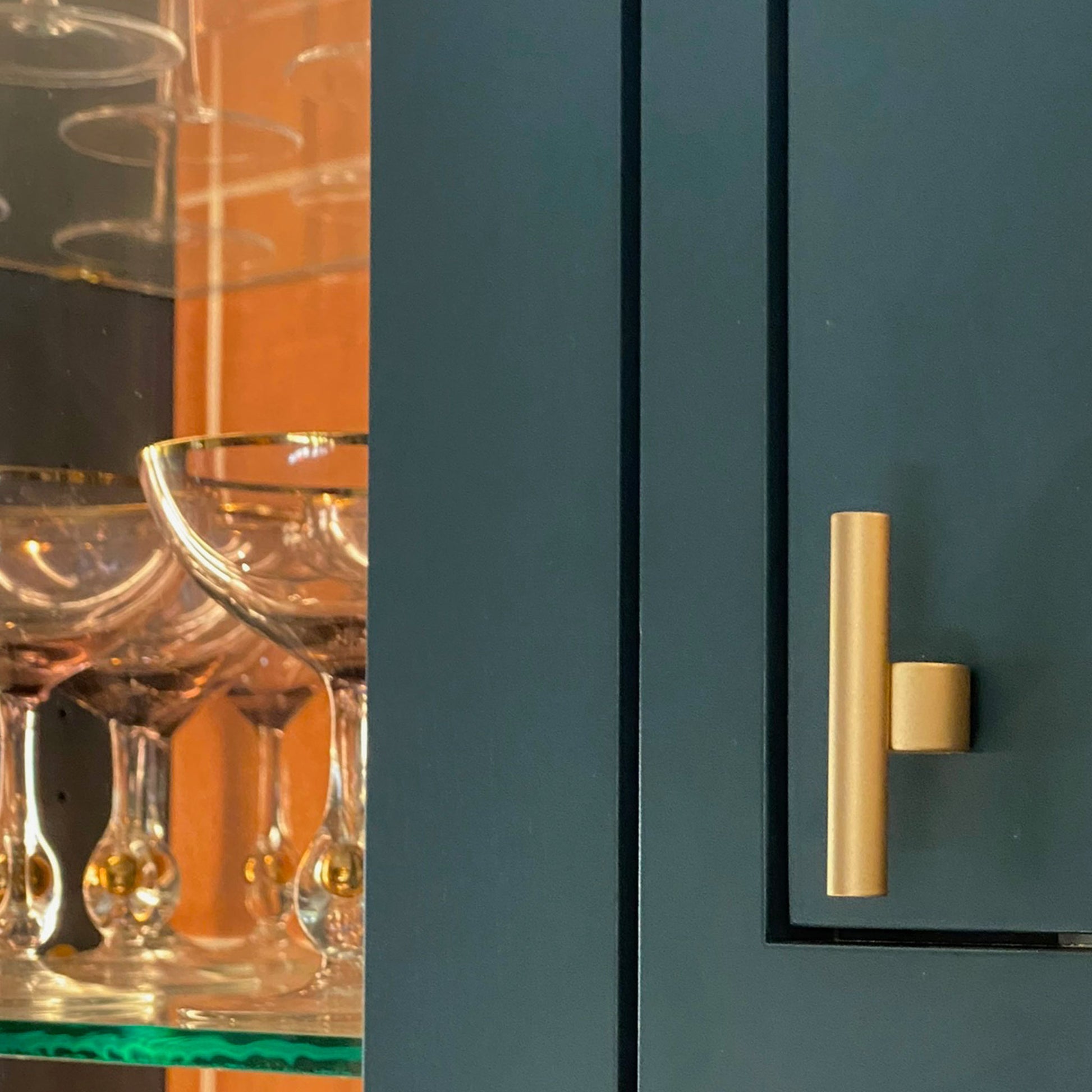 a counterbalace T-Pull in Satin Brass installed in a colorful kitchen door