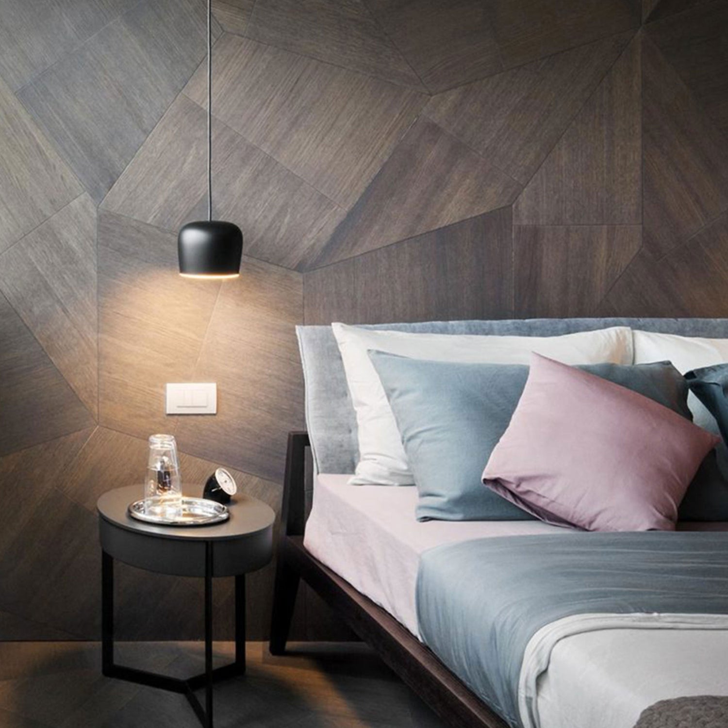 A hanging sconce at bedside set against Natural Genius Walnut Slide wood wall cladding.
