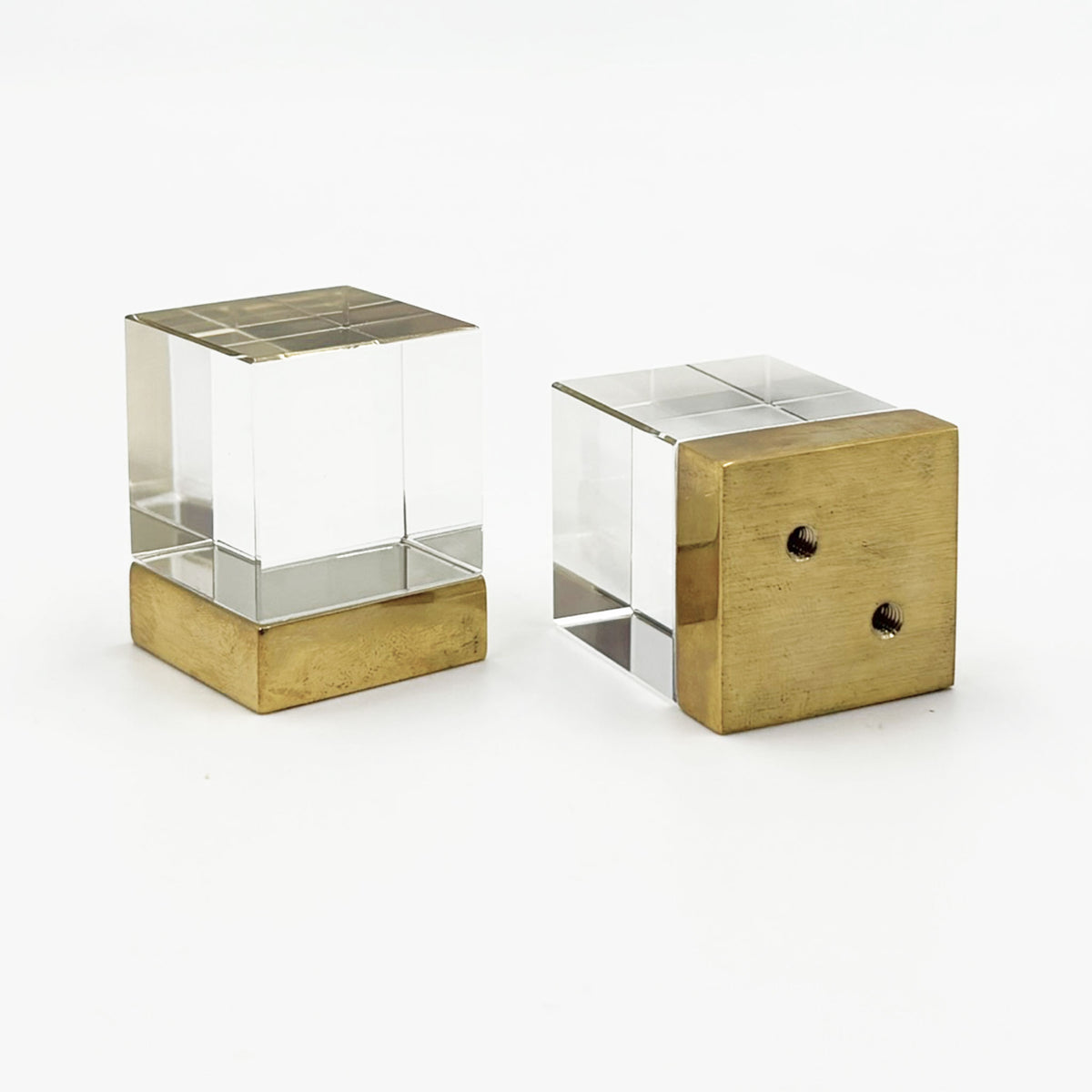 Two Glass cube shaped cabinet knobs with unlacquered brass bases on a white background