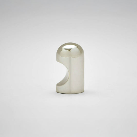 A small metallic cabinet knob with a rounded top and a curved cutout on the side, photographed on a clean light gray studio background.