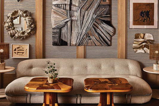 eclectic living area with collected art on a grassclot feature wall with a focus on wood tones