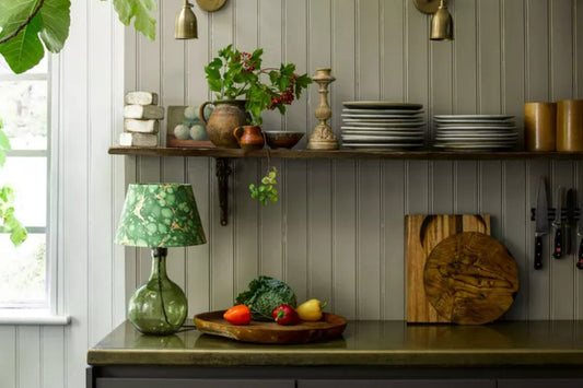 A small kitchen that uses layered lighting to enhance the small space by using wall-mounted task lighting and tabletop lighting