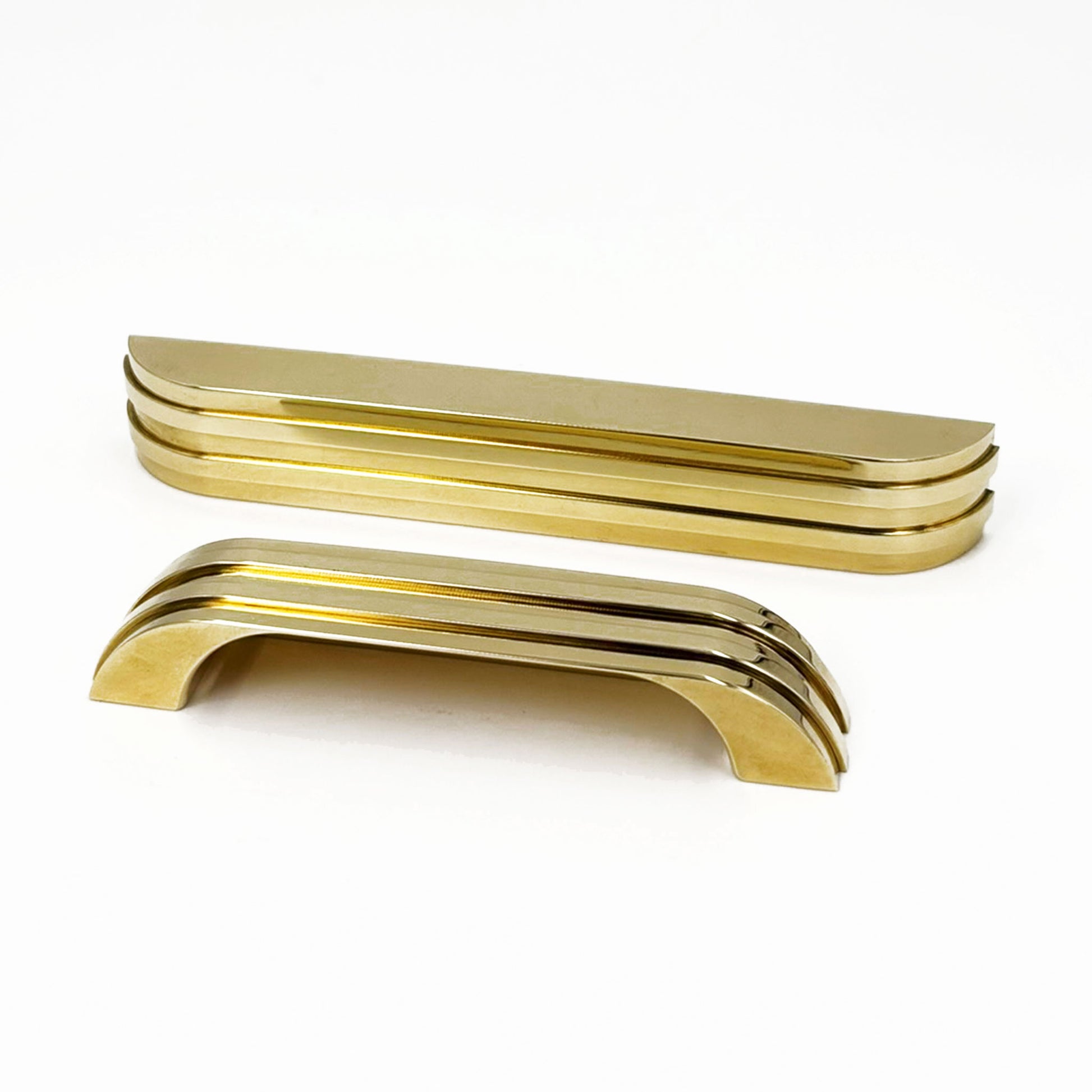 a ribbed brass metal bar cup pull  facing front next to a small brass pull turned with the grip side facing  us on a white background