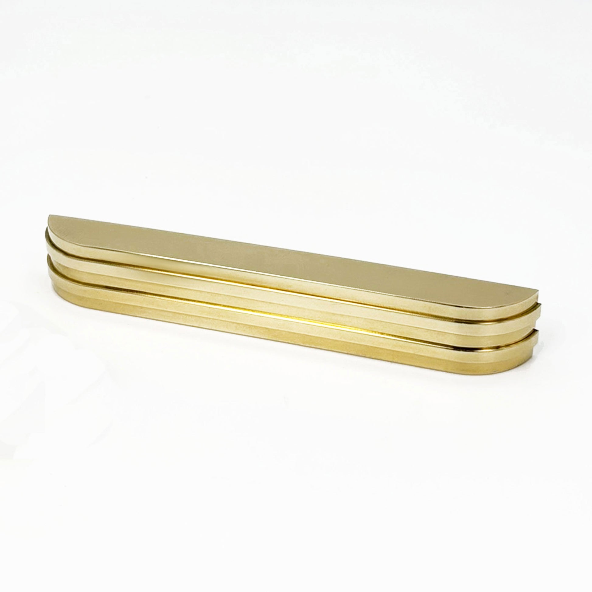 Angeled View of the ribbed brass Carrara Cup Appliance pull on a white 