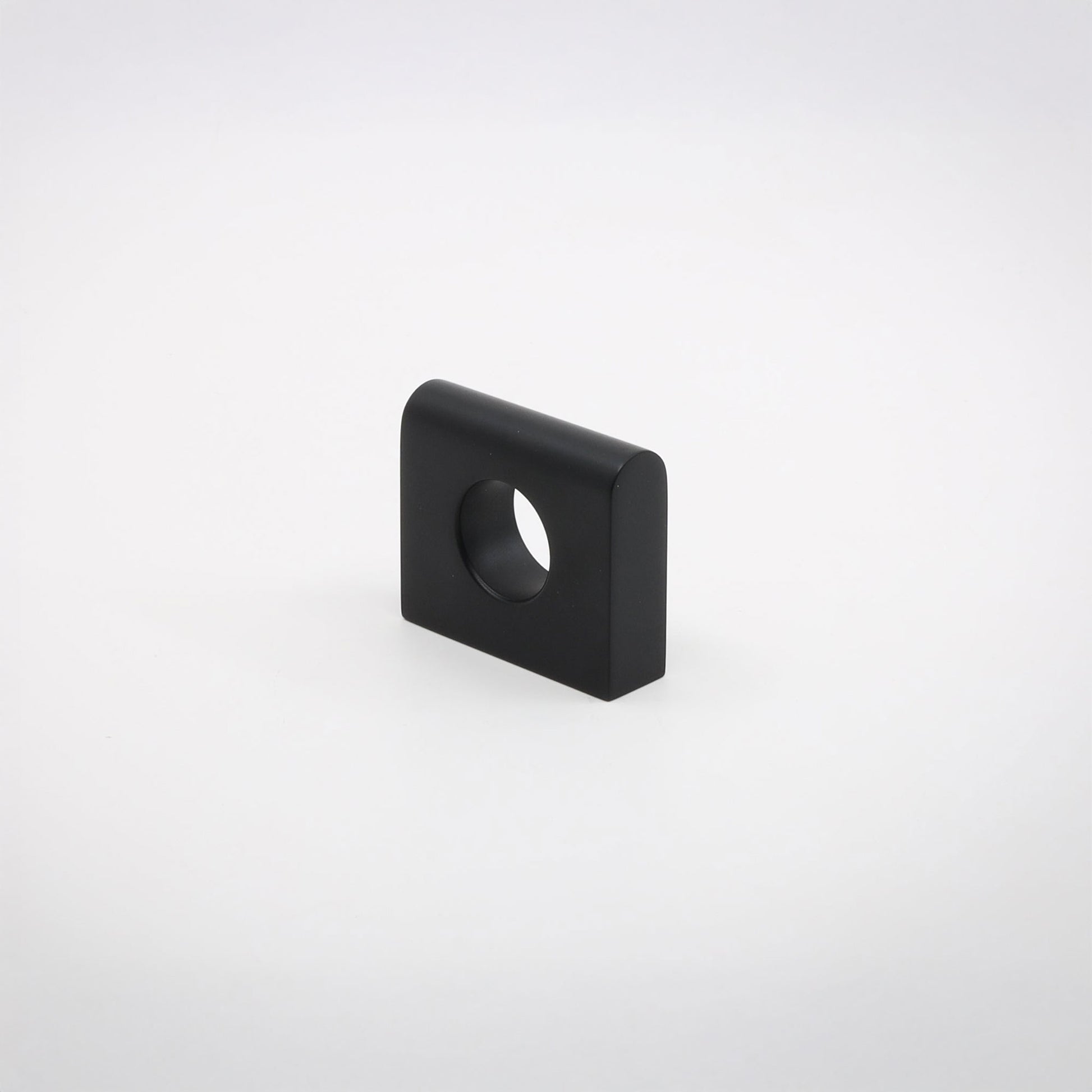 A small square metallic hardware piece with rounded corners and a circular hole, shown on a clean light gray background.