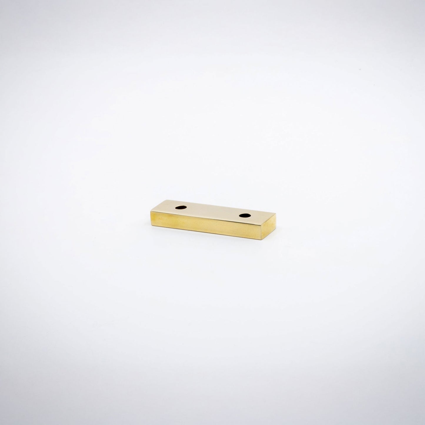A small rectangular polished brass hardware piece with two pre-drilled holes, shown on a plain white background.