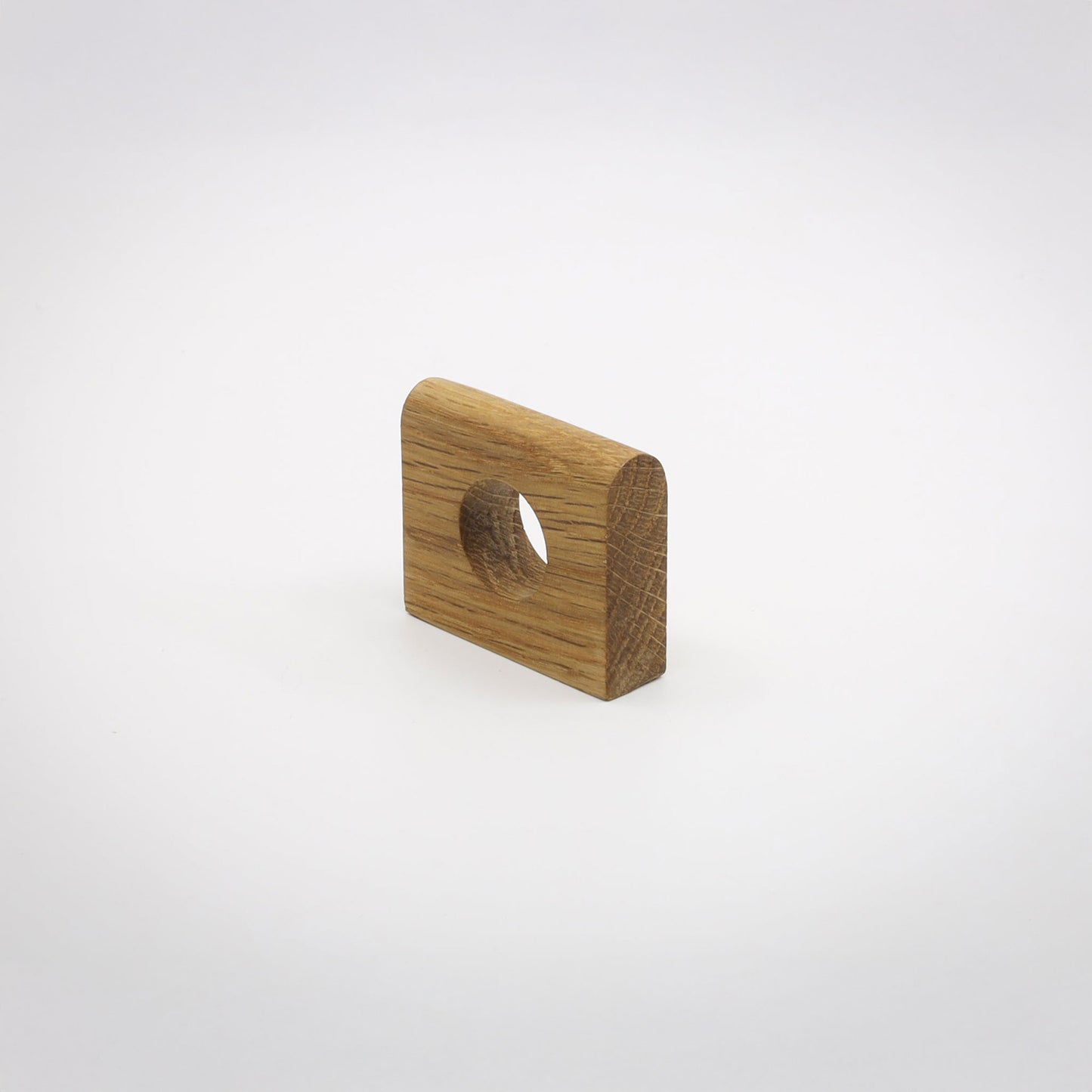 A small square wood hardware piece with rounded corners and a circular hole, shown on a clean light gray background.