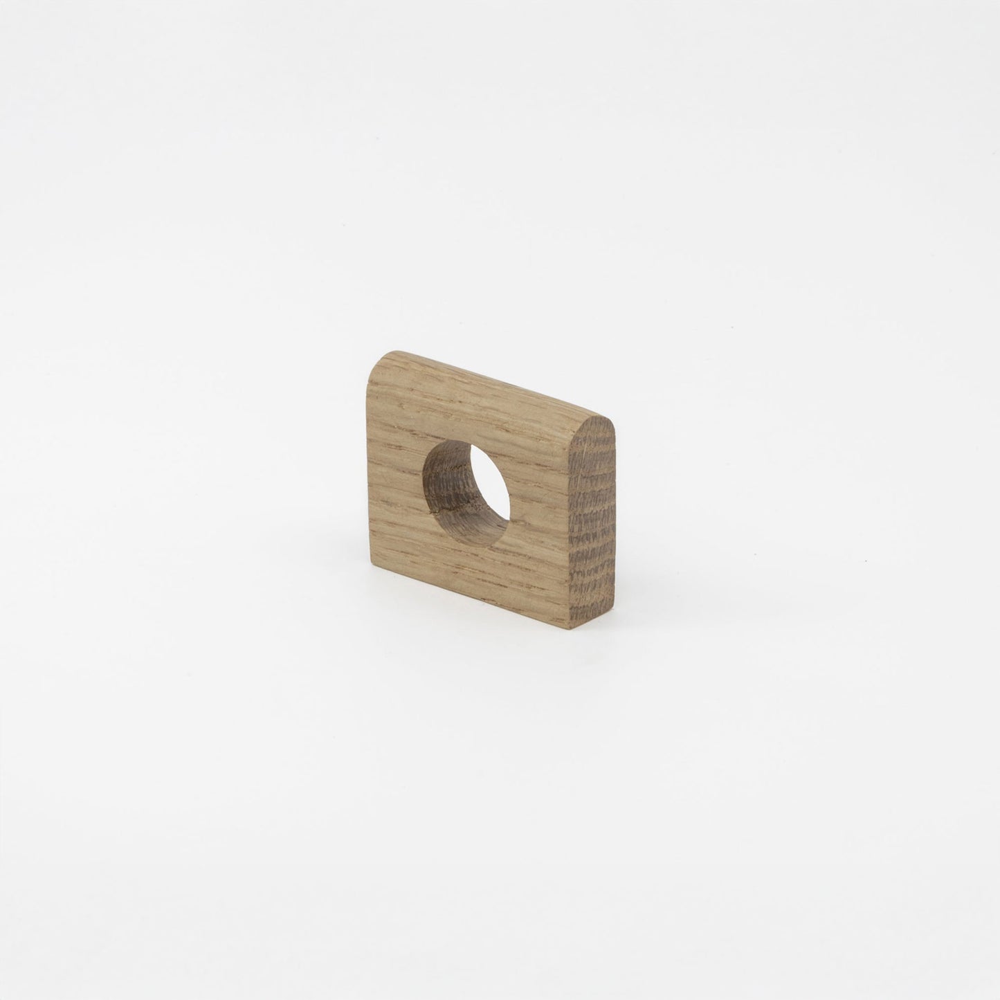 A small square wood hardware piece with rounded corners and a circular hole, shown on a clean light gray background.