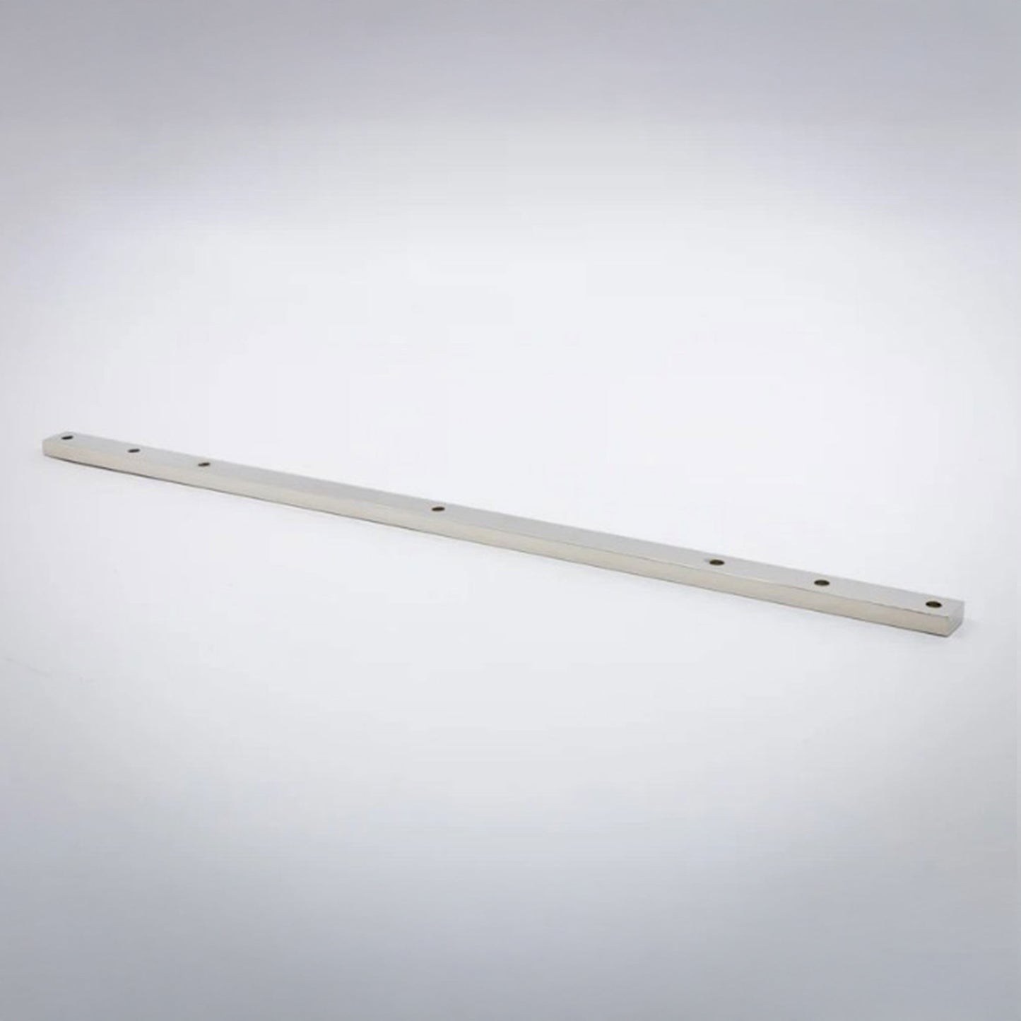 A long, thin polished nickel metal bar with pre-drilled holes, photographed diagonally on a light gray gradient background.