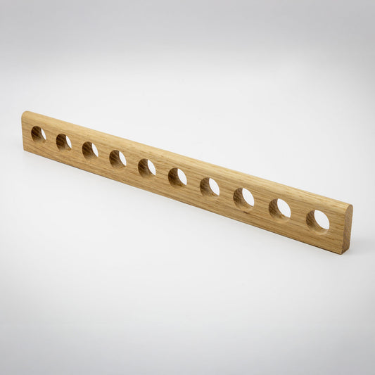A light natural wood rectangular bar with ten evenly spaced circular holes, shown on a clean light gray studio background.