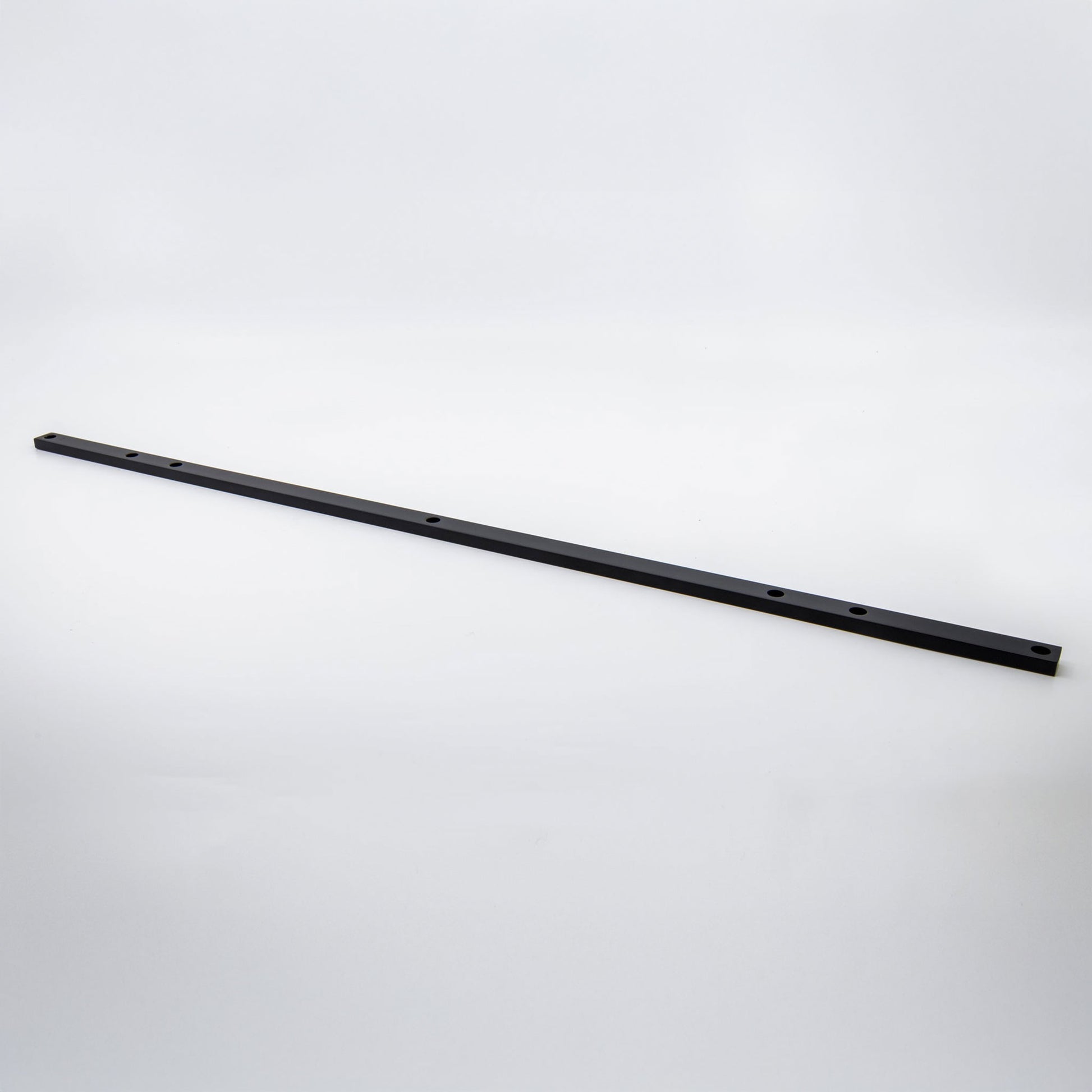 A long, thin black metal mounting bracket or hardware bar with pre-drilled holes, shown diagonally on a light gray studio background.