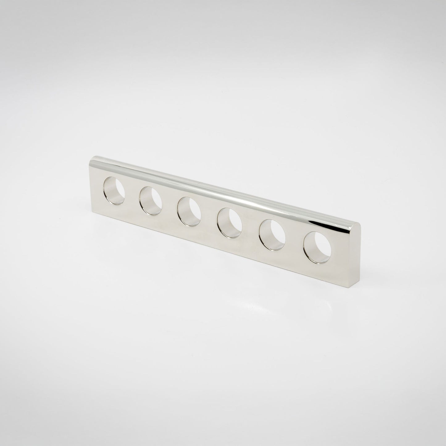 A silver-finished polished nickel metal handle with six evenly spaced circular cutouts, shown on a clean white studio background.