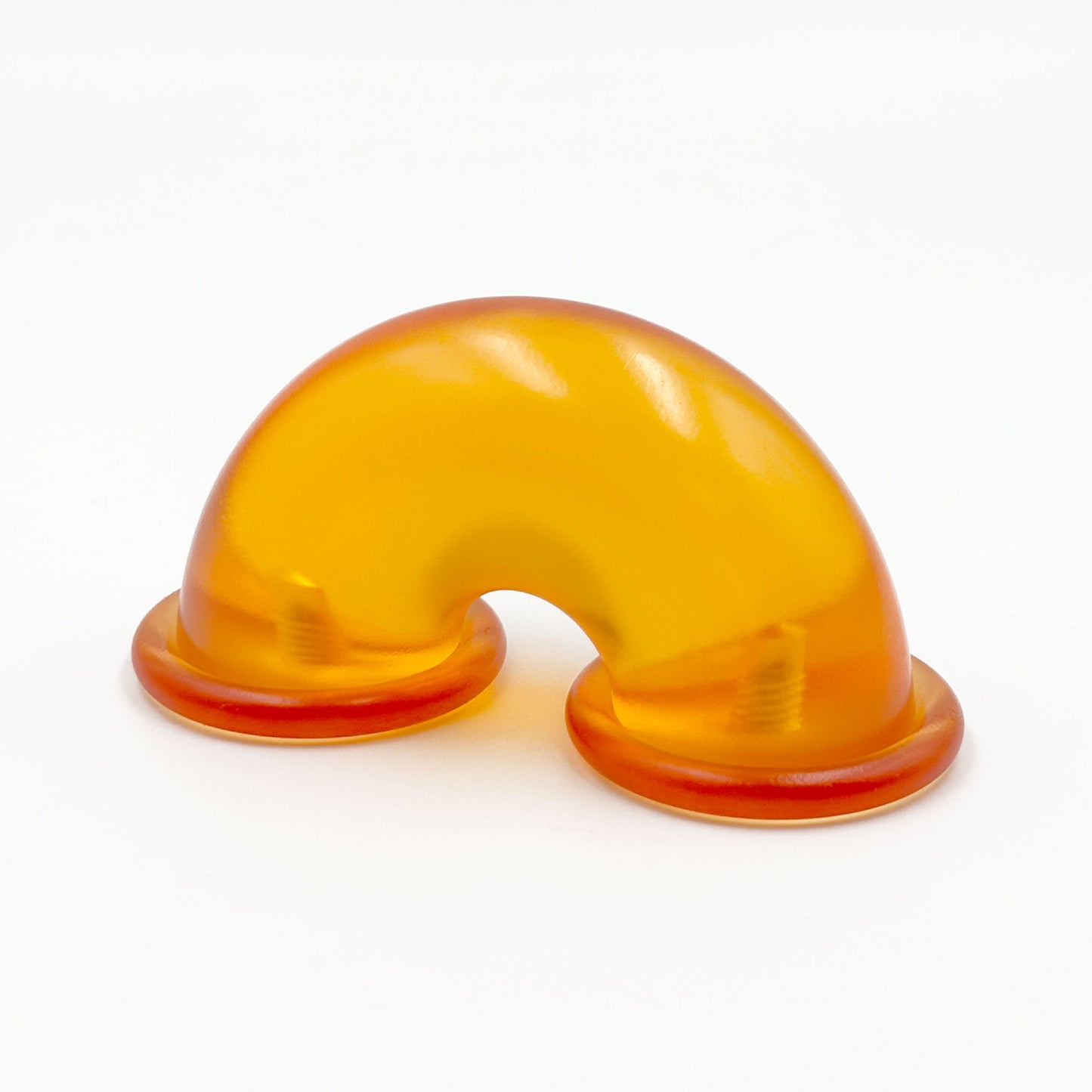 Translucent orange colored macaroni-shaped handles on a white background