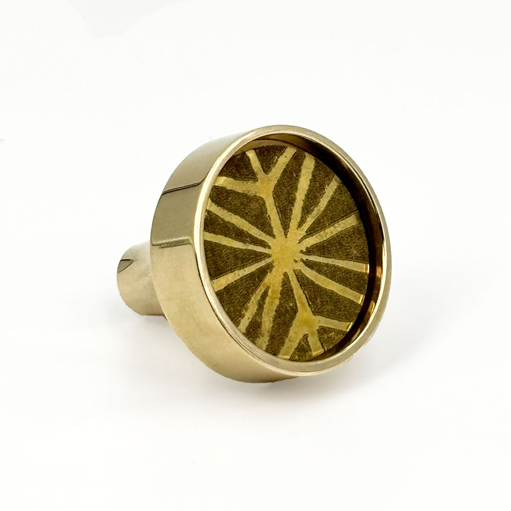 Patterned Aurora round cabinet pull on it side on a white background