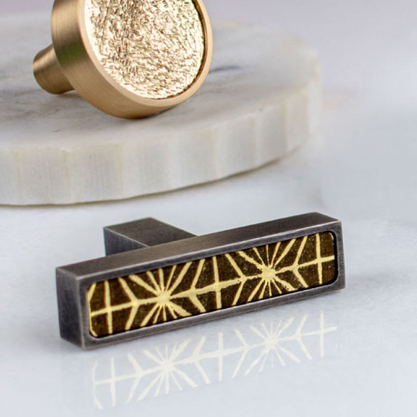 Antique Nickel and Brass cabinet T-[ull handle with geometric design on a white background