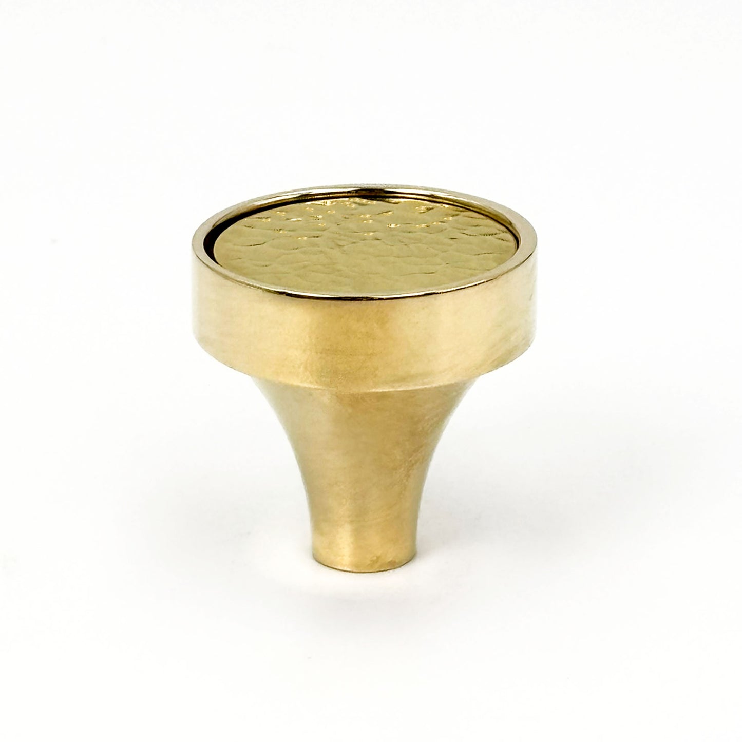 Brass cabinet knob with a textured surface on a white background