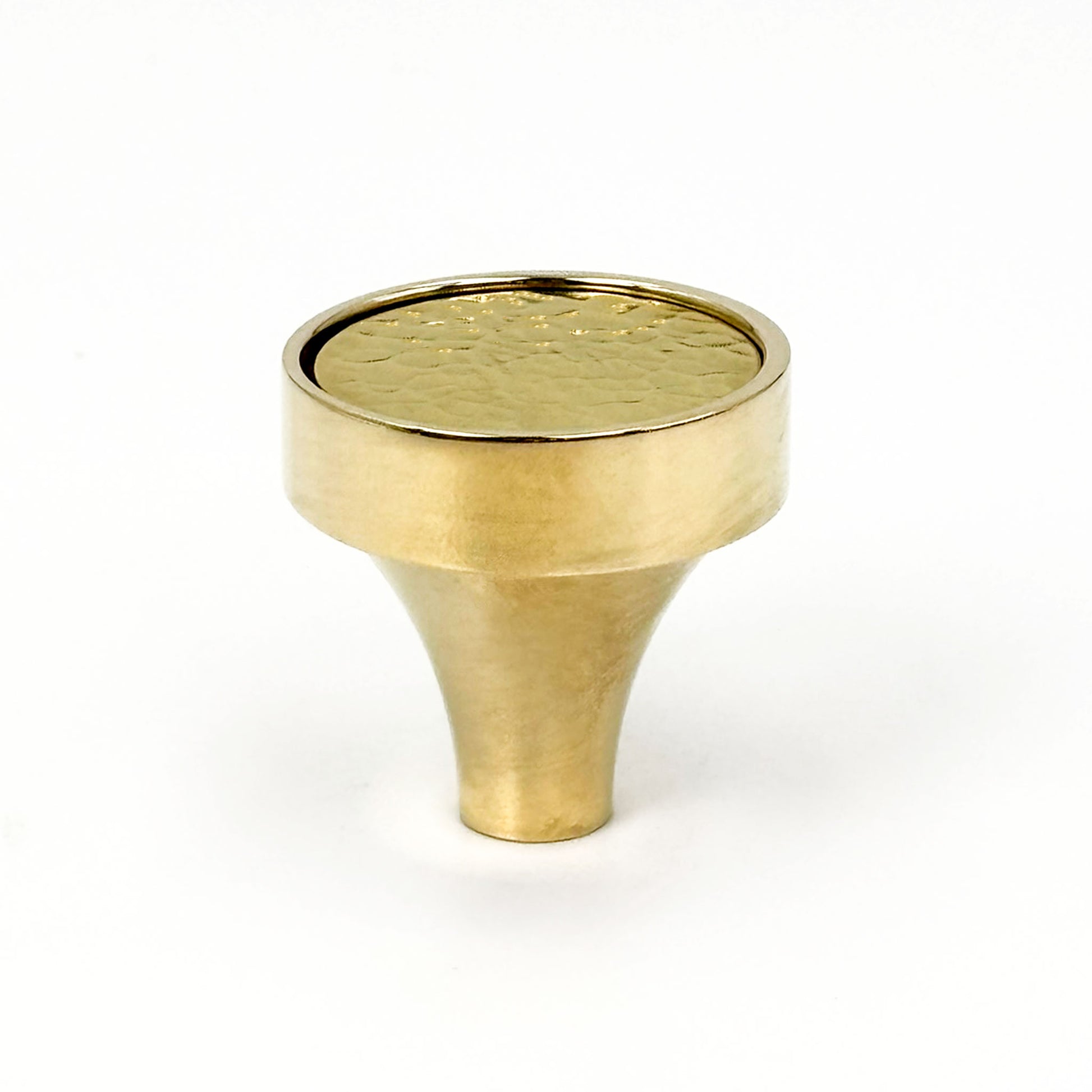 Brass cabinet knob with a textured surface on a white background