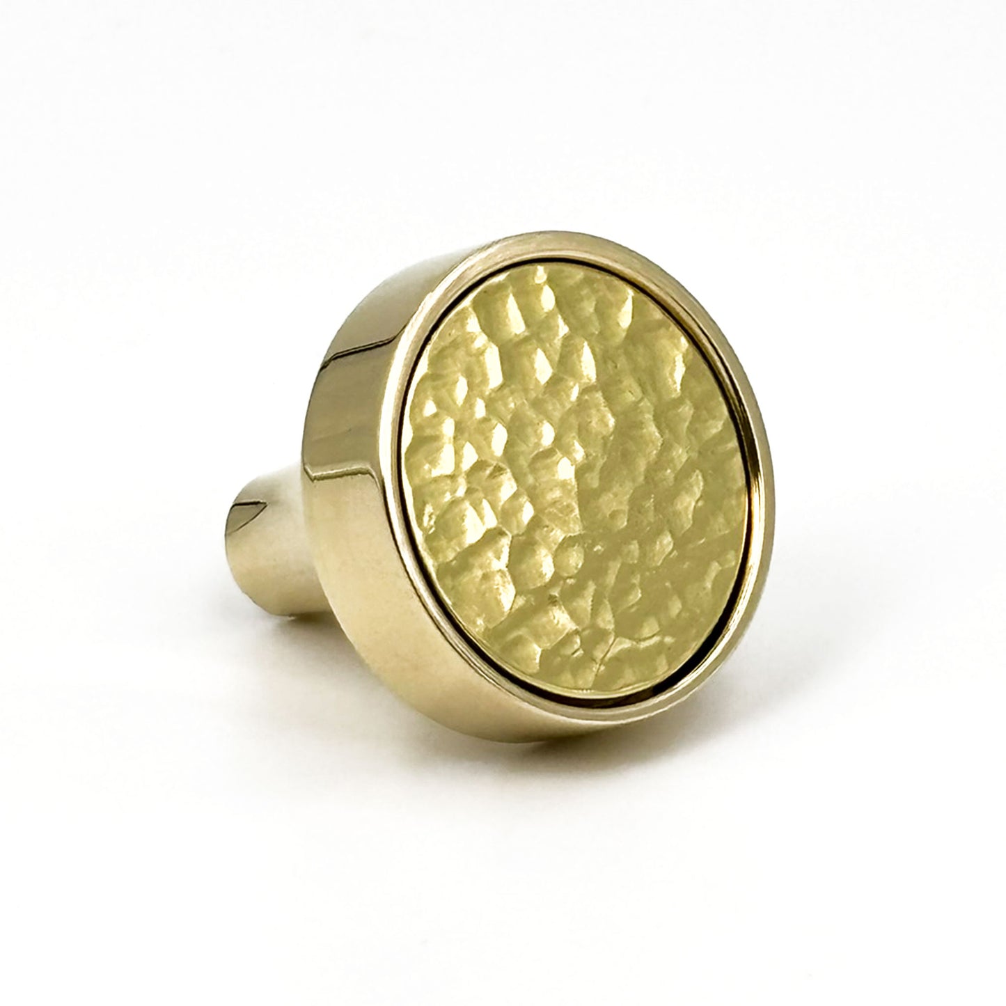 Brass cabinet knob with a textured surface on a white background