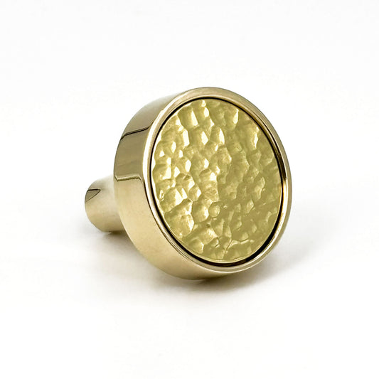 Brass cabinet knob with a textured surface on a white background