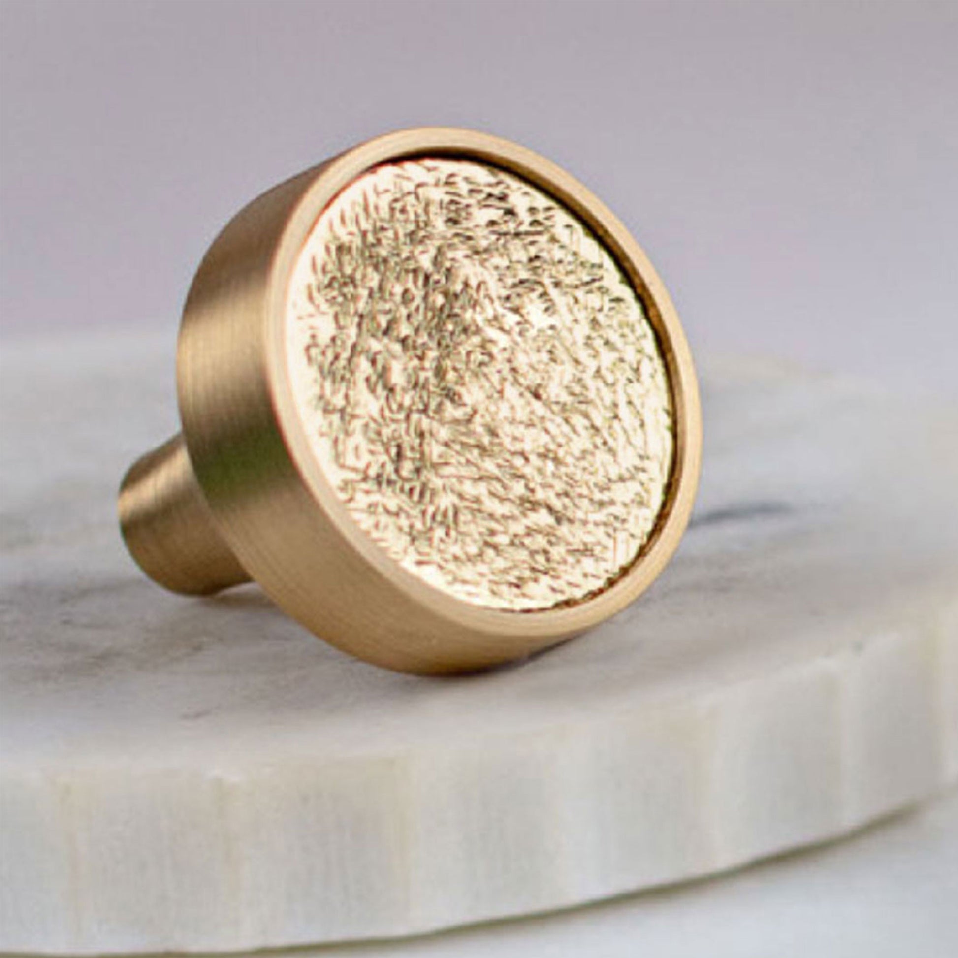 Satin Brass cabinet knob with a textured surface on a white background