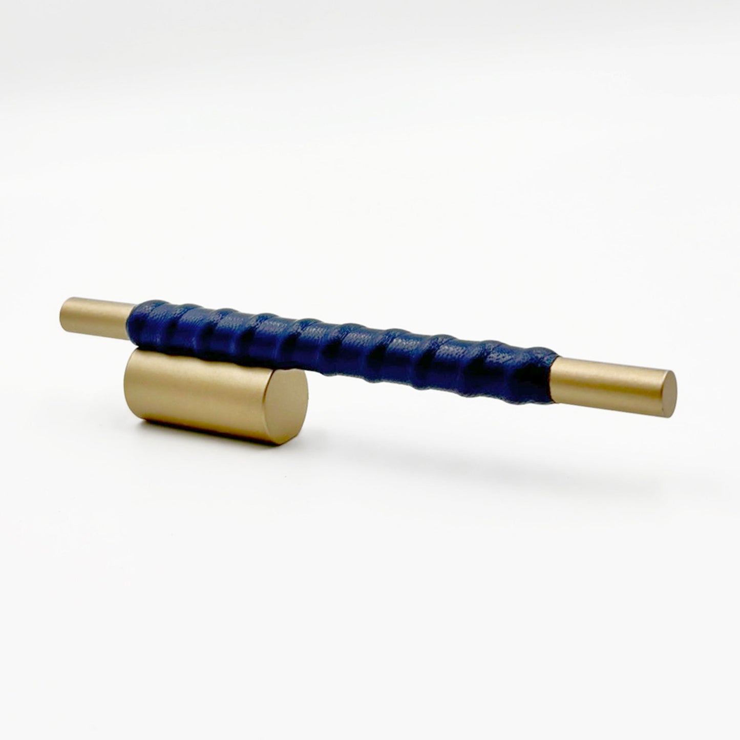 Satin Brass cylindrical cabinet pull with blue leather wraped handle on a white background