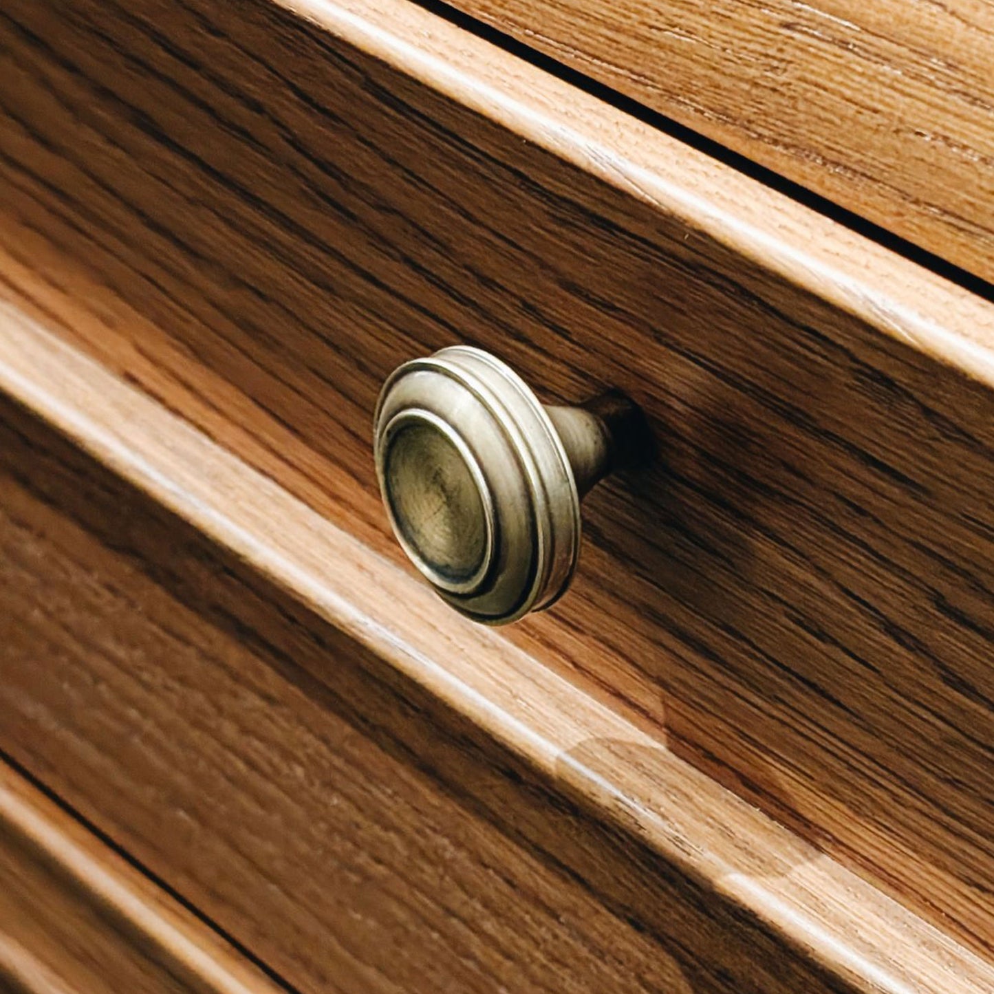 Close-up of a wooden drawer with a brass knob