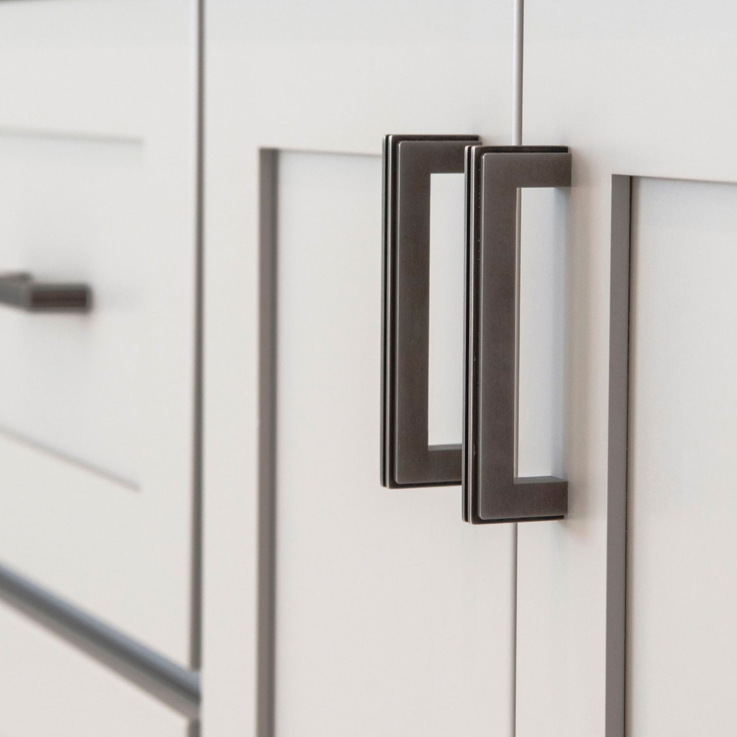 The Carrara Square cabinet pull mounted on shaker style cabinet doors