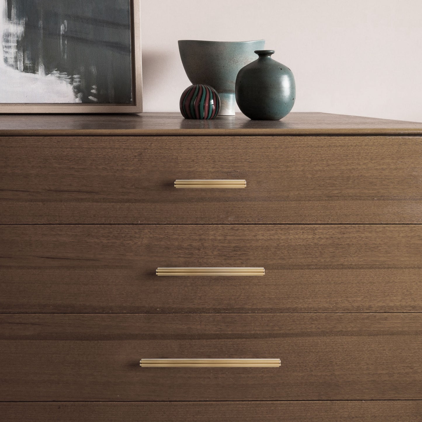 The Carrara Square cabinet pull in three different sizes mounted on cabinet drawers