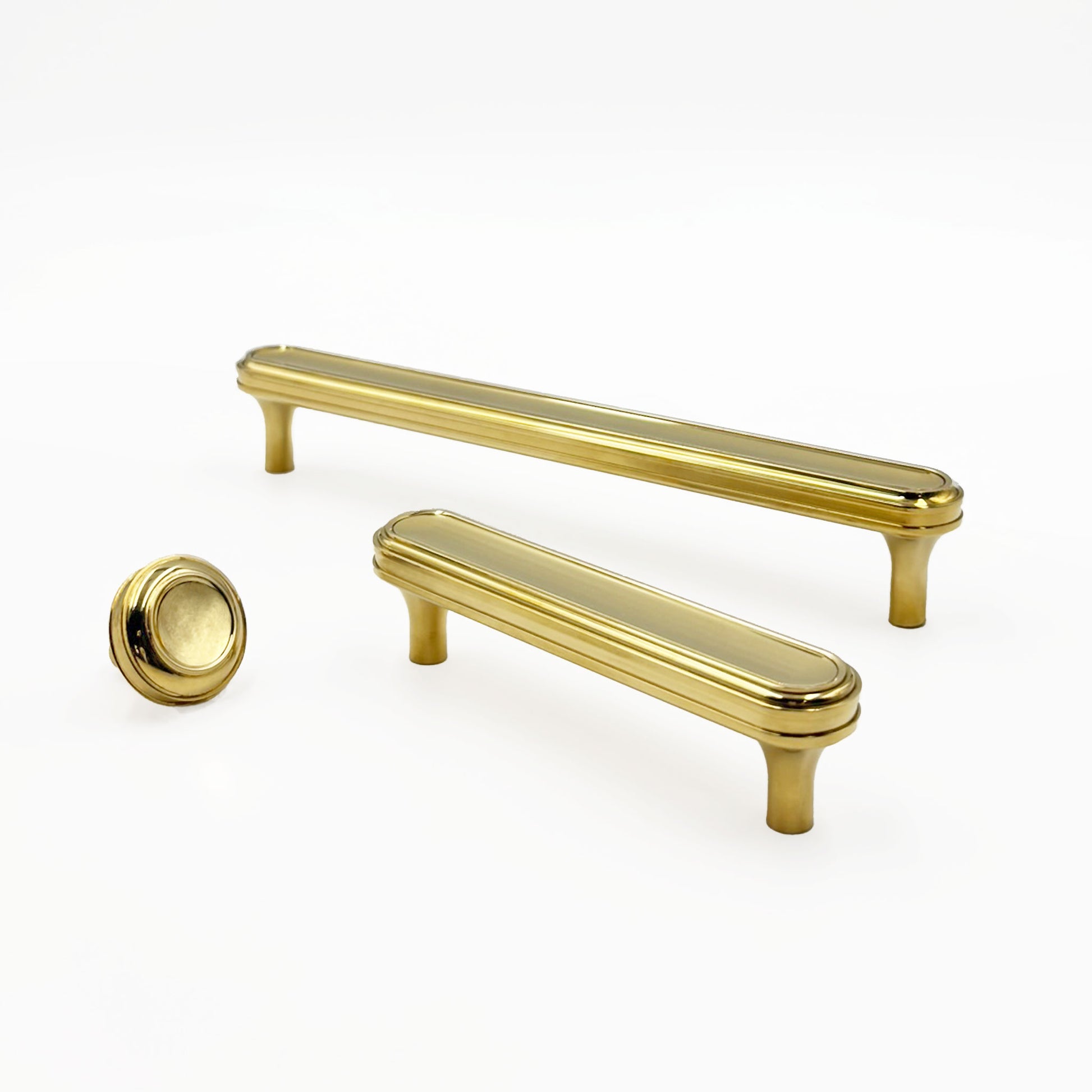 Two brass cabinet handles and a cabinet knob on a white background