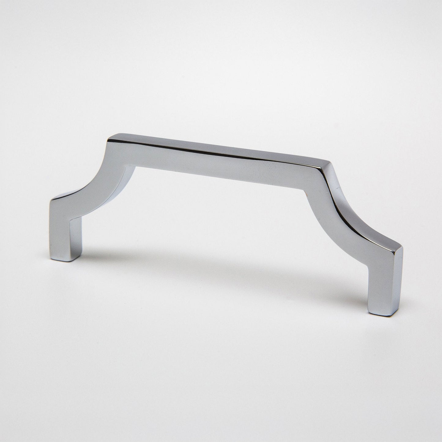 A polished chrome cabinet pull handle with a curved corner design on a clean white background.