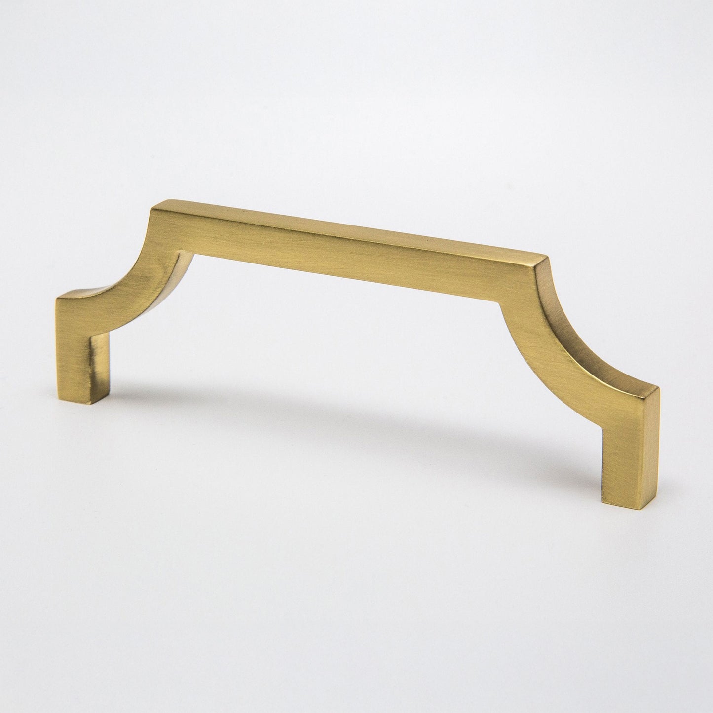 A satin brass cabinet pull handle with a curved corner design on a clean white background.