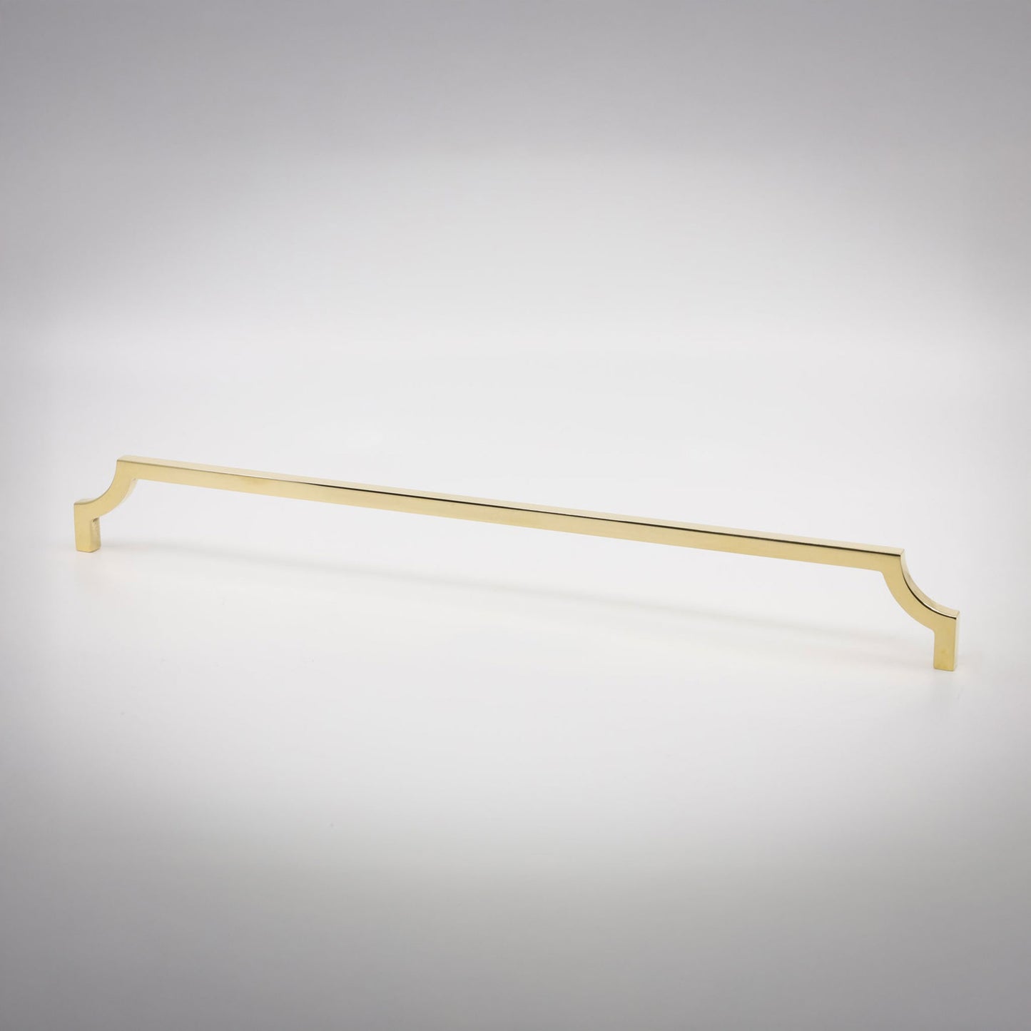 A long, slender cabinet pull handle with decorative scrolled ends, finished in a unlaquered brass, shown on a clean light gray background.