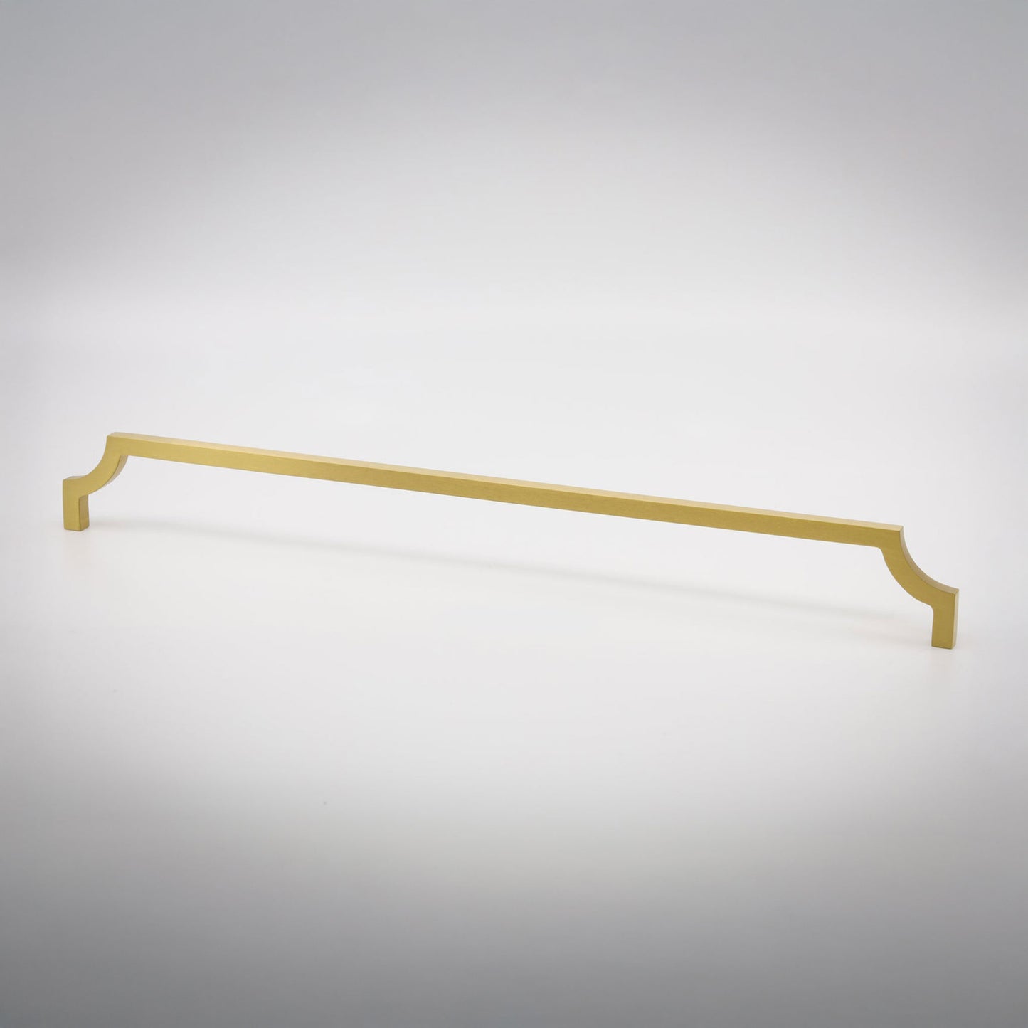 A long, slender cabinet pull handle with decorative scrolled ends, finished in a matte brass, shown on a clean light gray background.