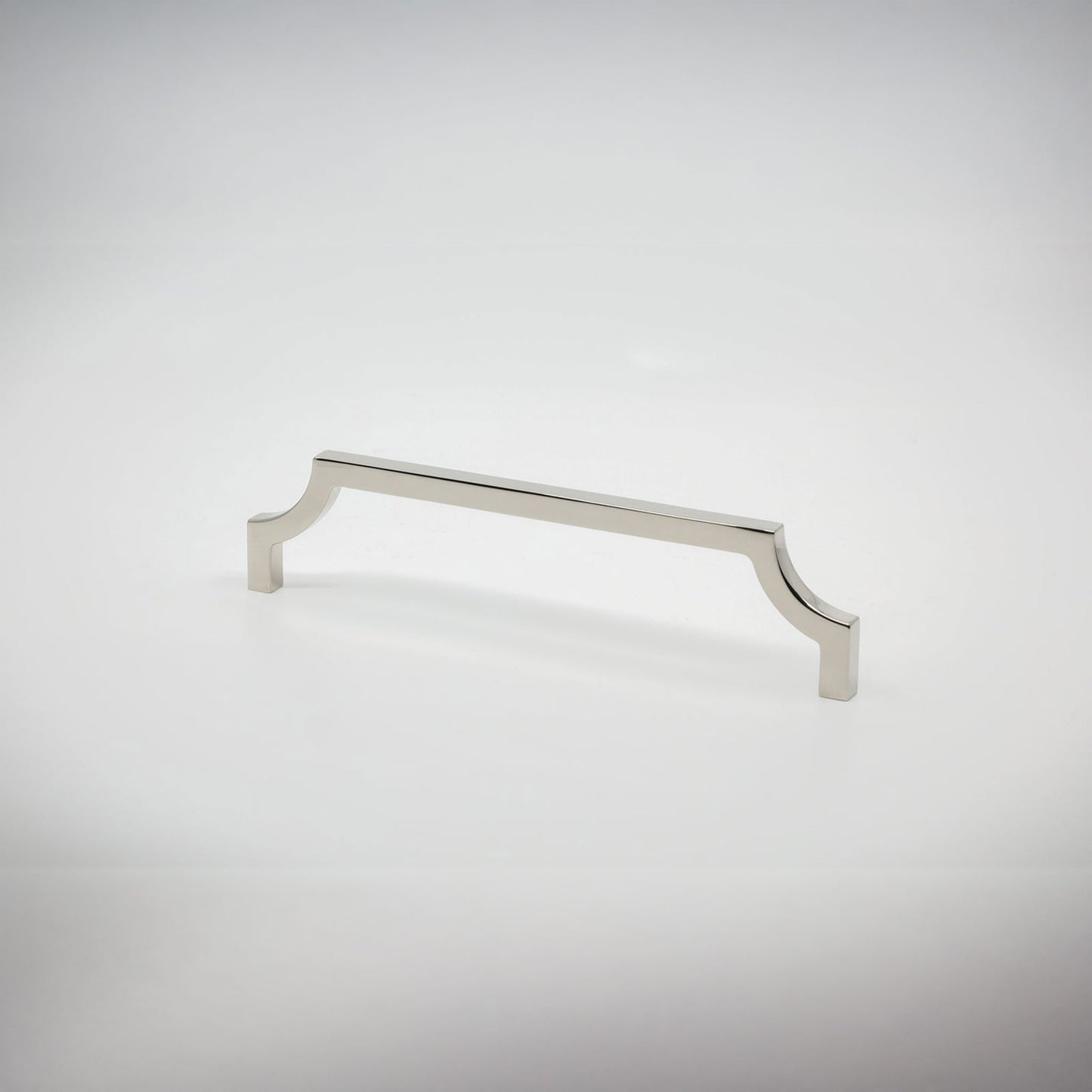 A polished nickel cabinet pull handle with decorative scrolled ends, shown on a light gray gradient background.