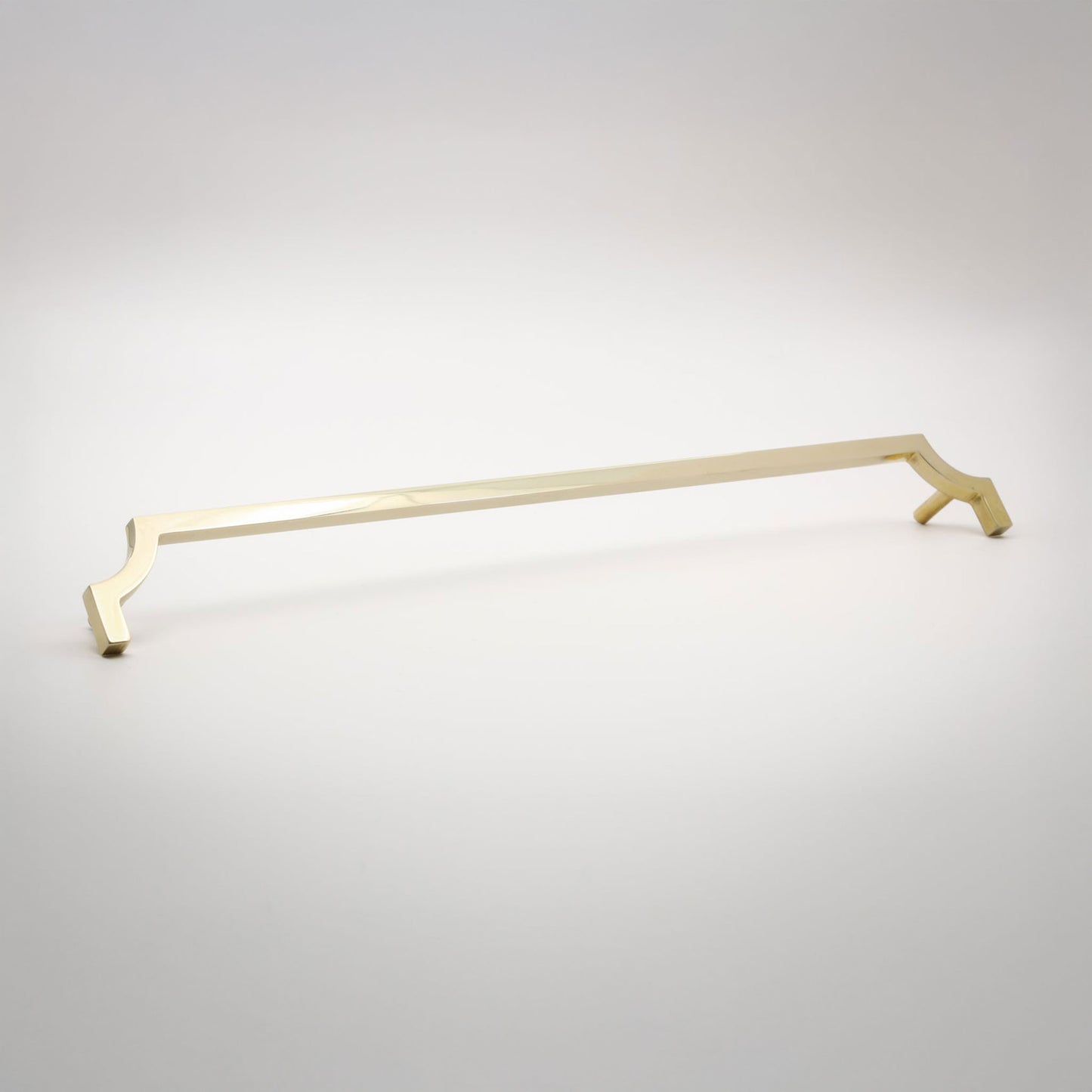 A long, slender cabinet pull in a polished unlaquered brass finish shown against a neutral background.