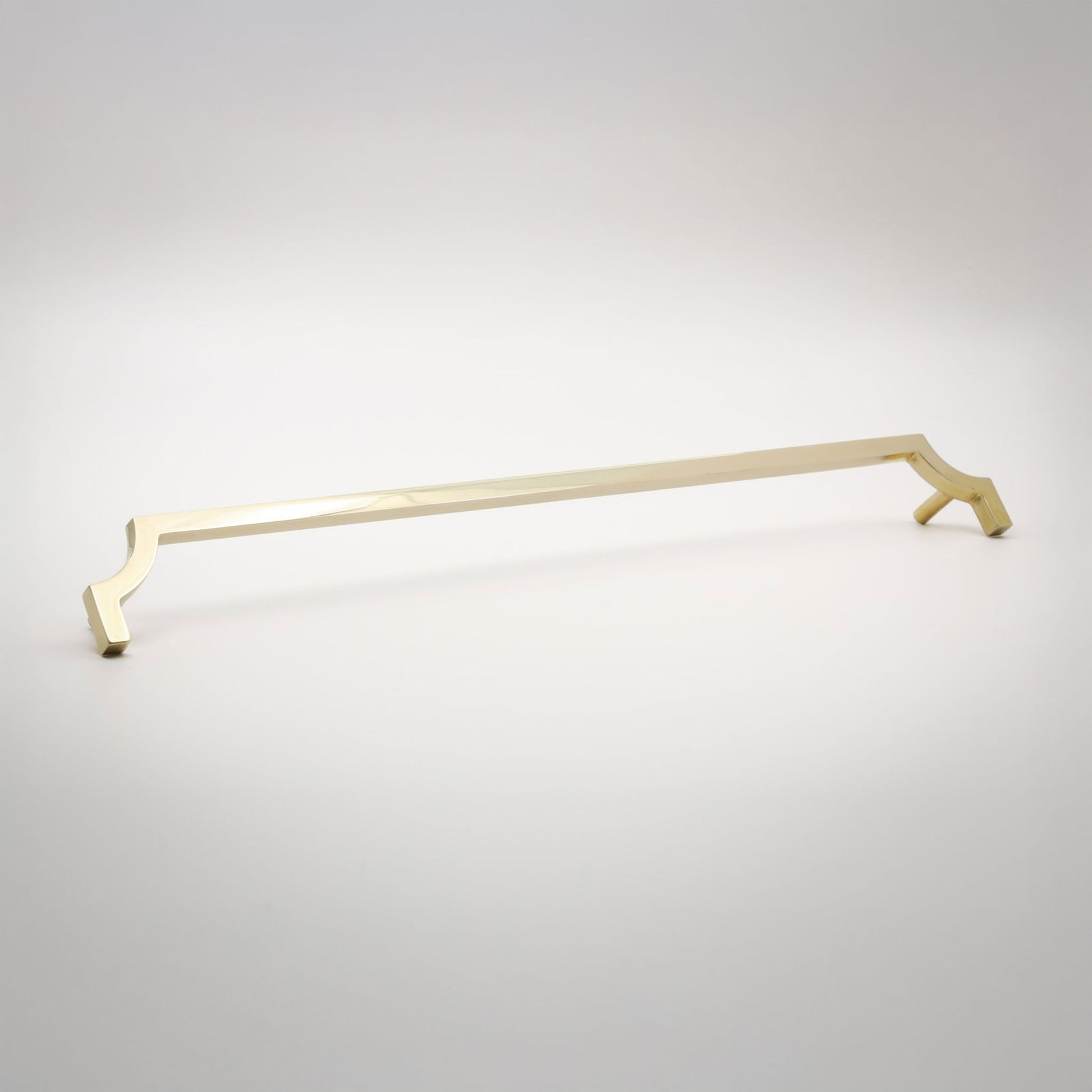 A long, slender cabinet pull in a polished unlaquered brass finish shown against a neutral background.