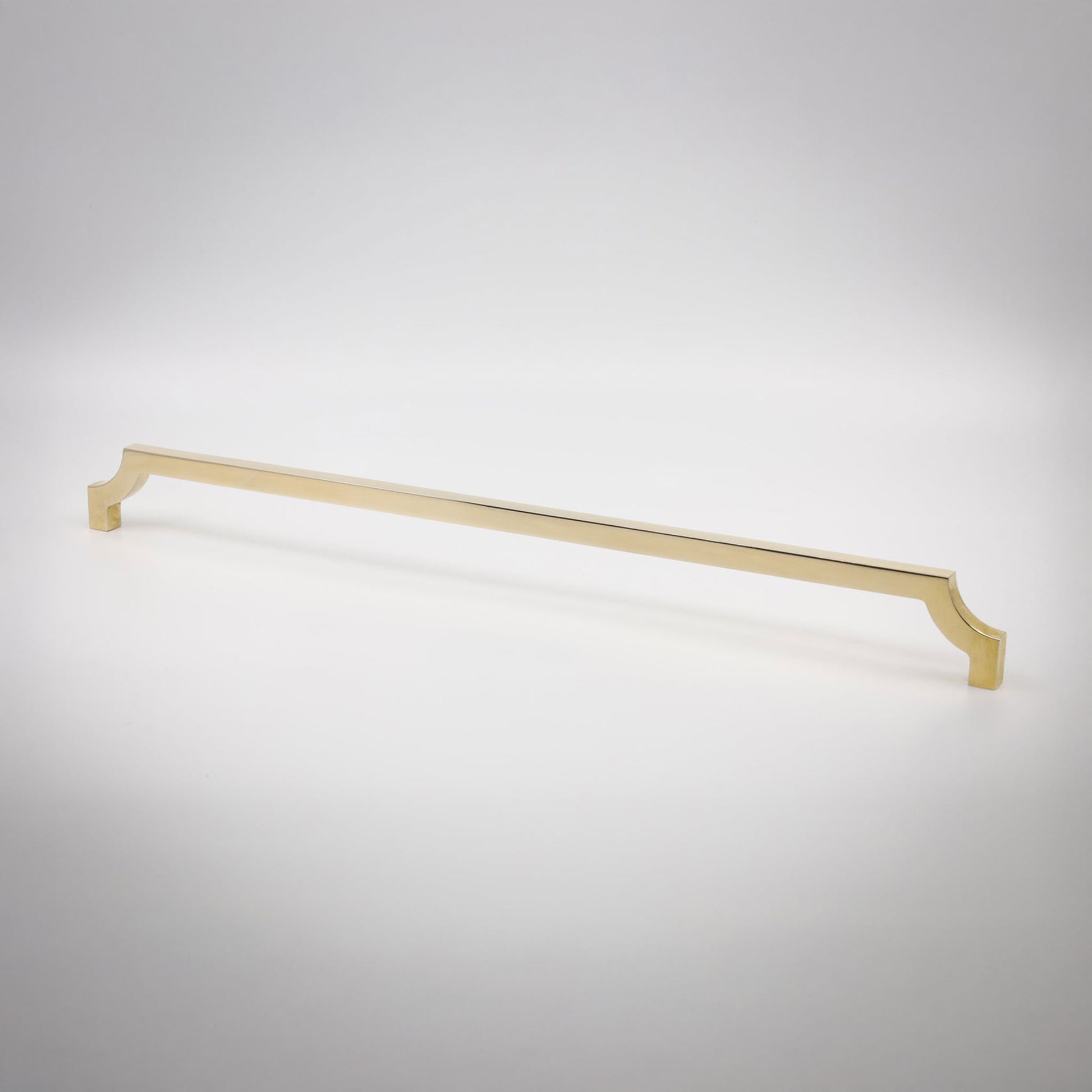 A long, slender cabinet pull in a polished unlaquered brass finish shown against a neutral background.