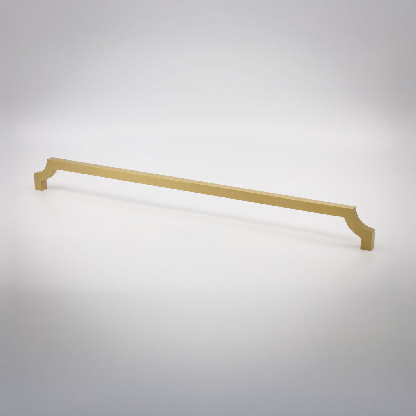 A long, slender cabinet pull in a satin brass finish shown against a neutral background.