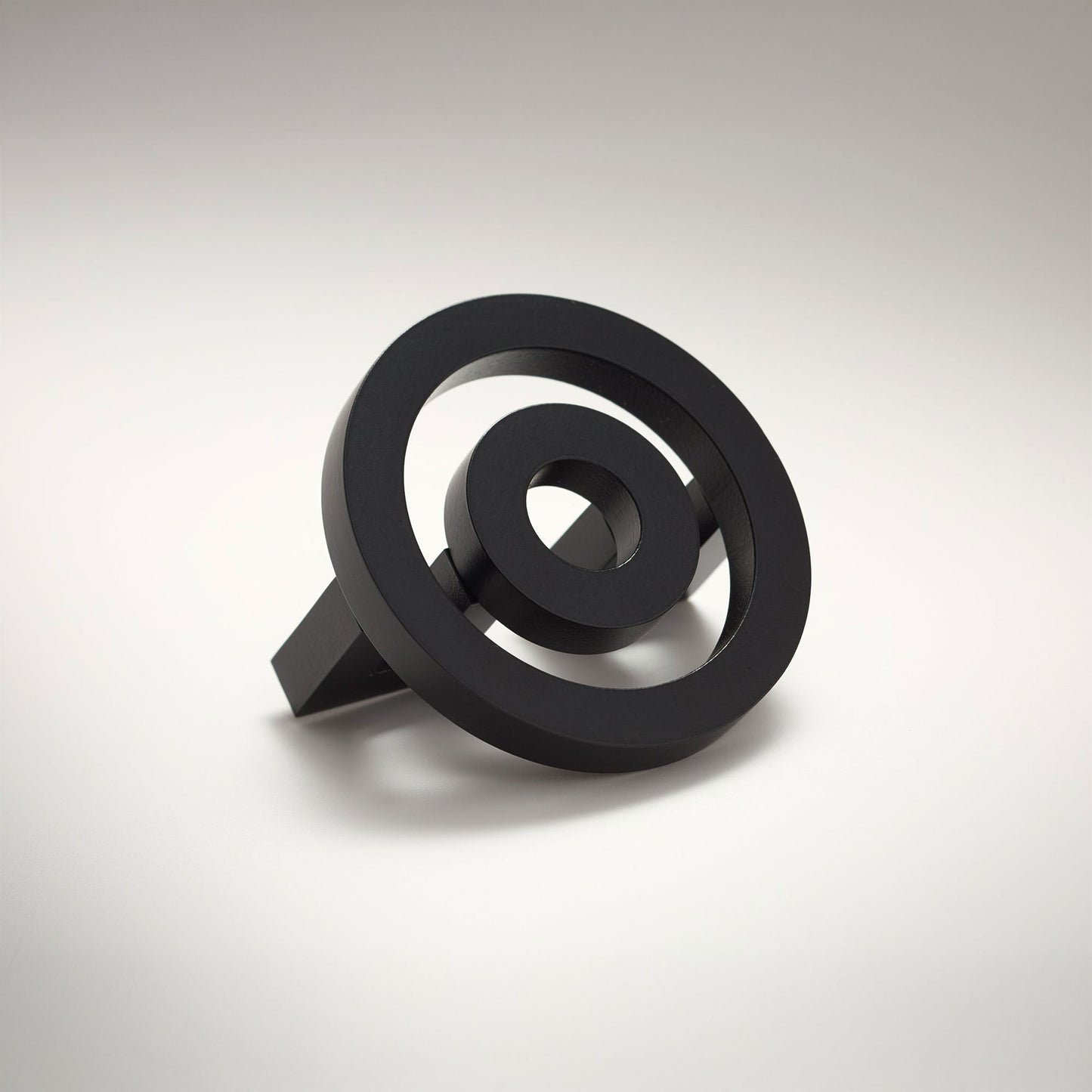 Concentric circle shaped cabinet knob on a grey background