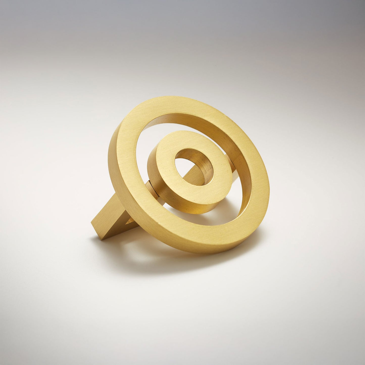 Concentric circle shaped cabinet knob on a grey background