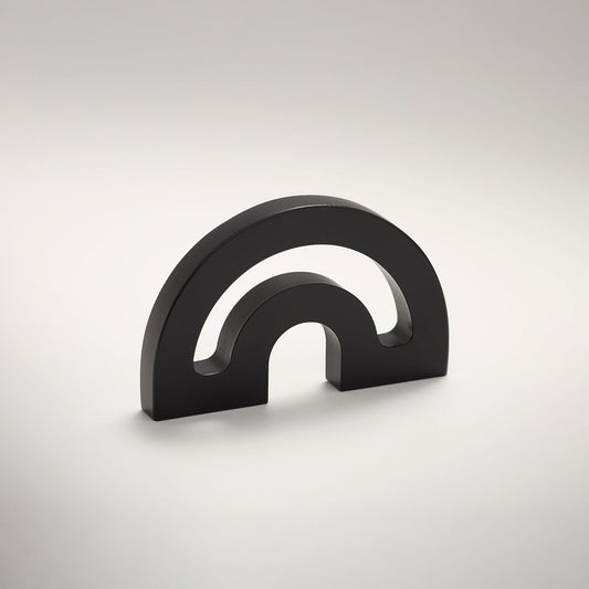 A minimalist metal cabinet knob with a double-arch design, photographed on a clean light gray gradient background.