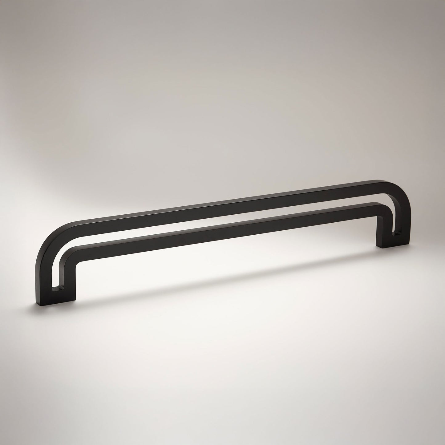 Arch shaped linear cabinet pull with cut our internal area on a grey background