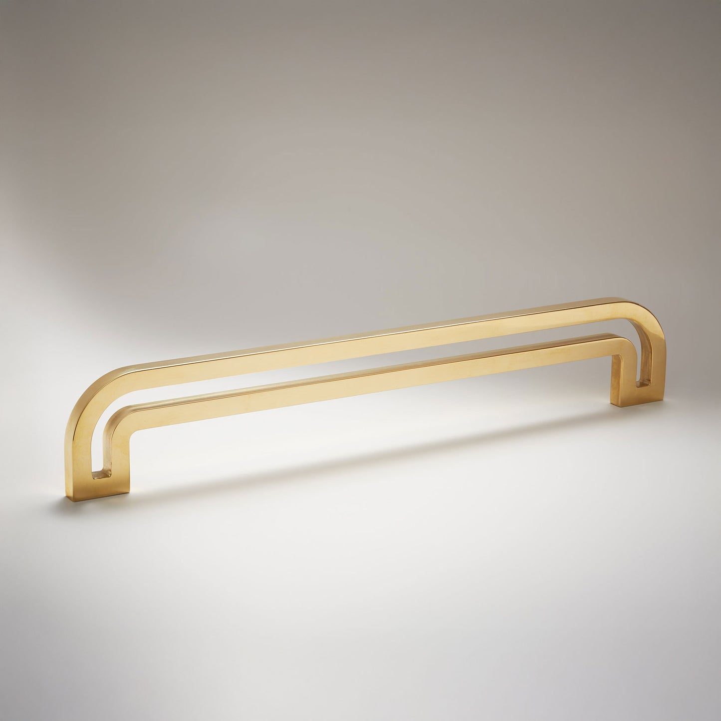 Arch shaped linear cabinet pull with cut our internal area on a grey background