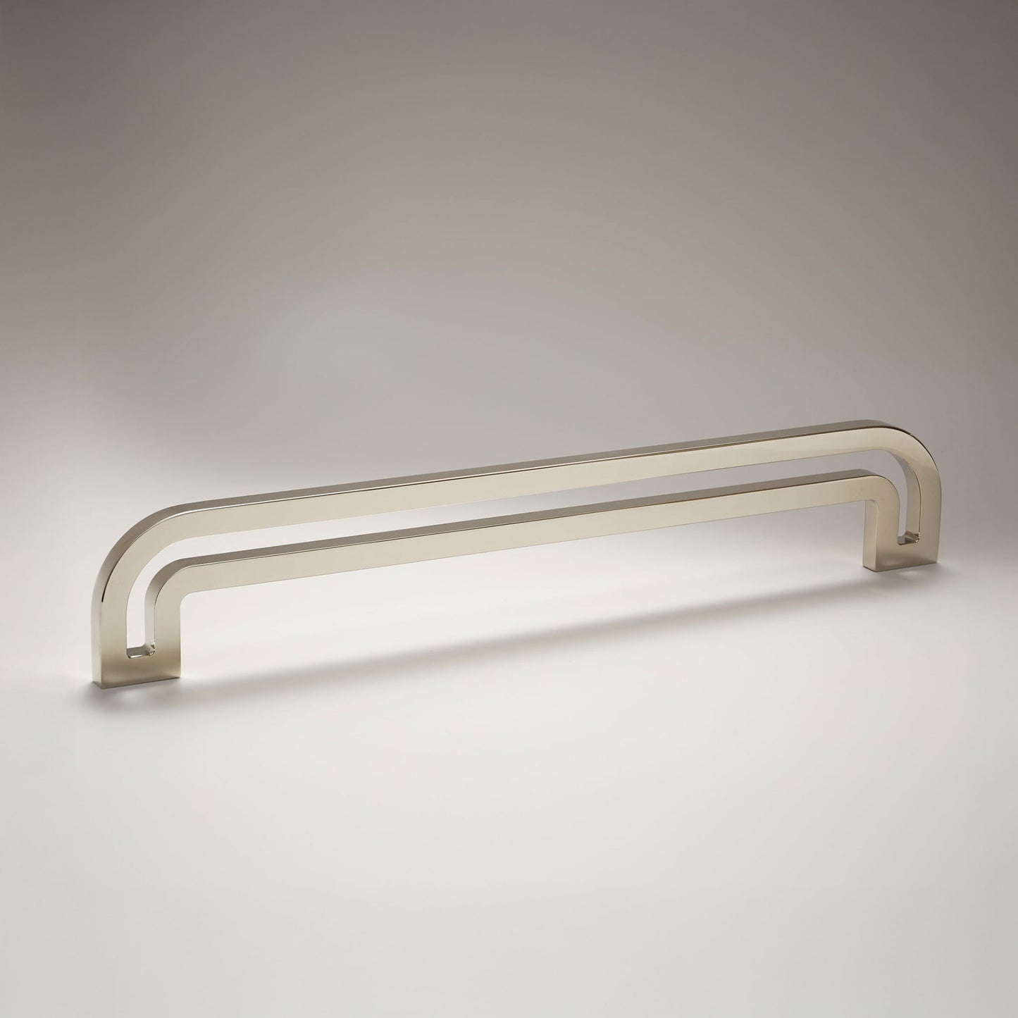 Arch shaped linear cabinet pull with cut our internal area on a grey background