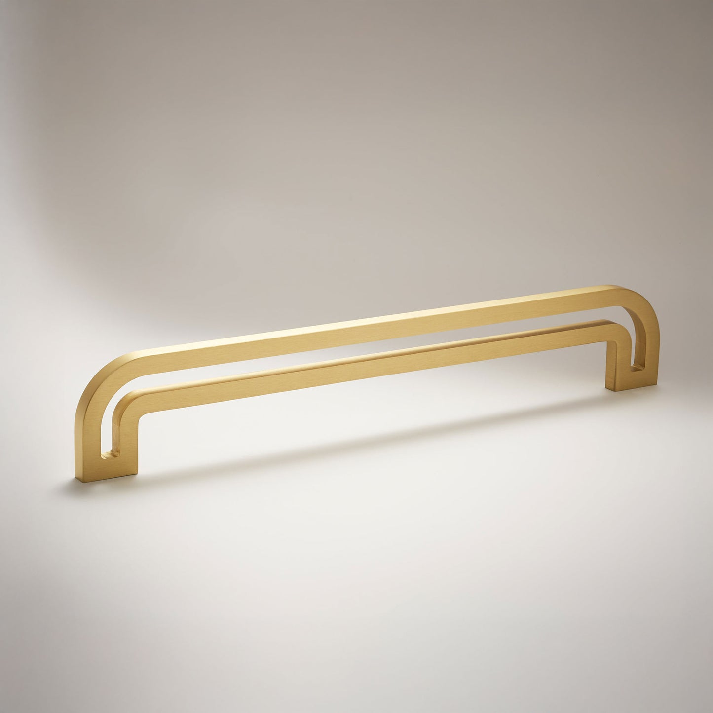 Arch shaped linear cabinet pull with cut our internal area on a grey background